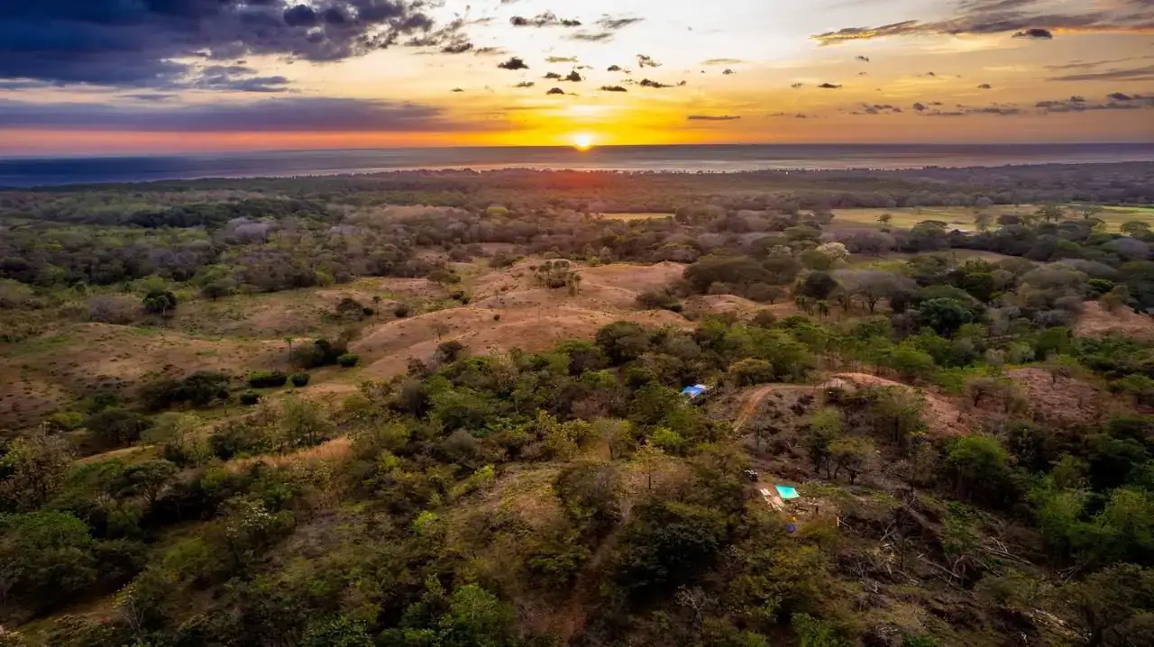 Sunset over rolling green hills at Ocean View Ridge Farm, Playa Venado